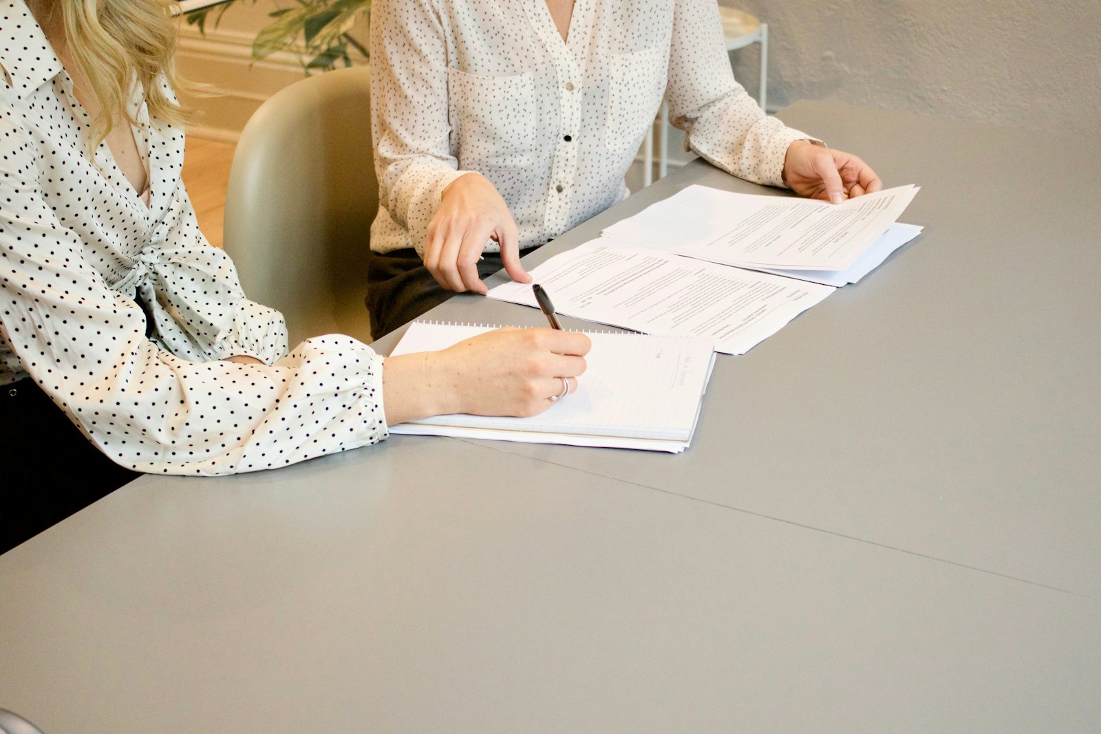 Two people going through paperwork together at a table