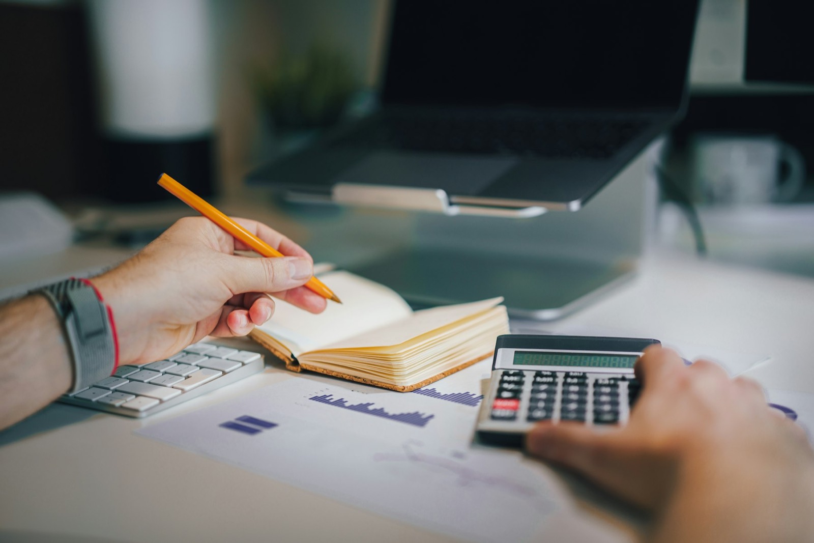 A notebook, pencil and calculator on a desk