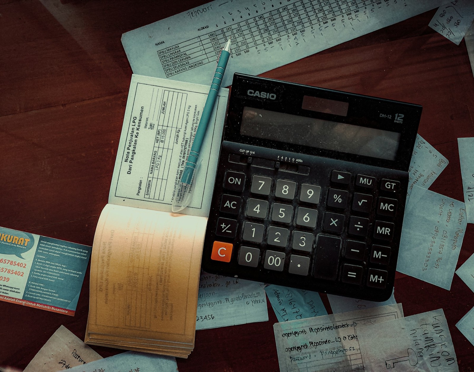 A calculator and receipts on a wooden desk