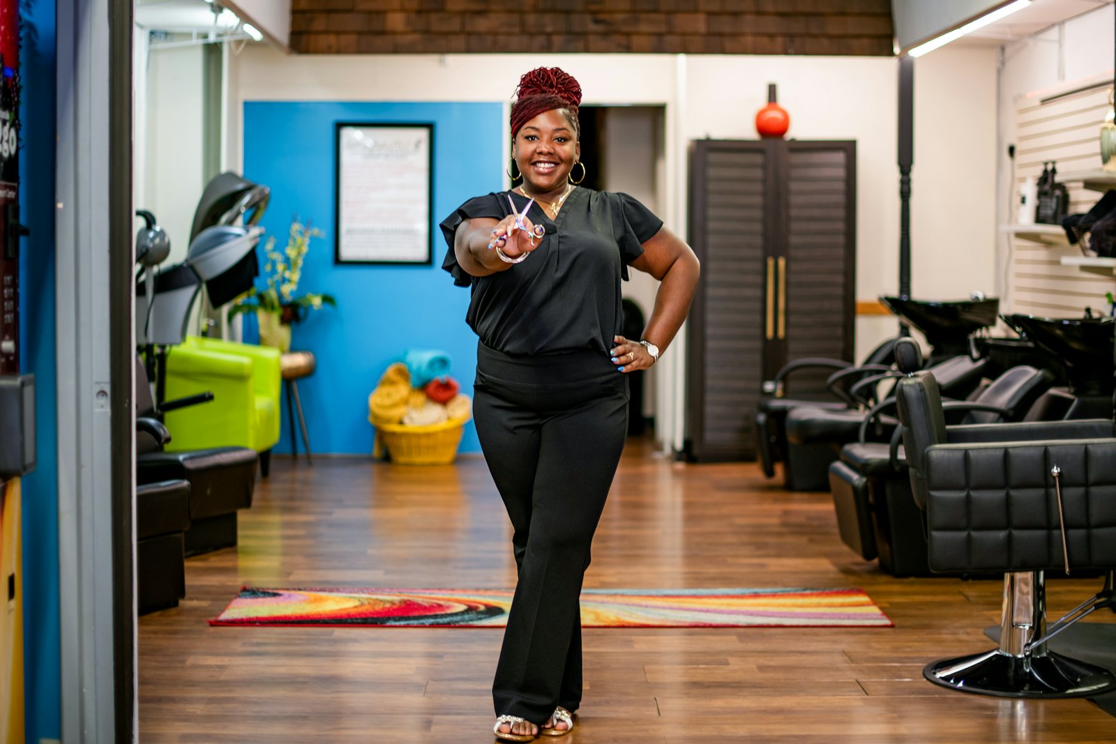 A salon owner standing in her studio between the styling chairs