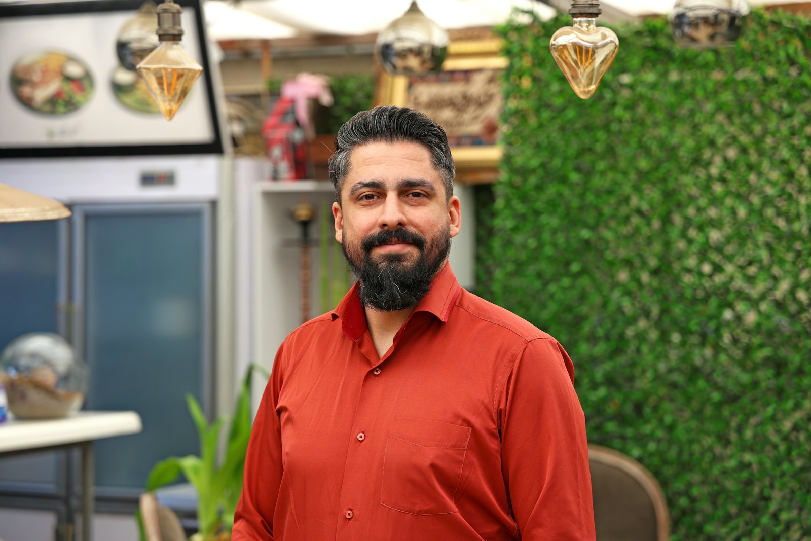 A shop owner standing among the lamps and homeware he sells